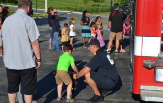 Firefighter assisting child during demonstration