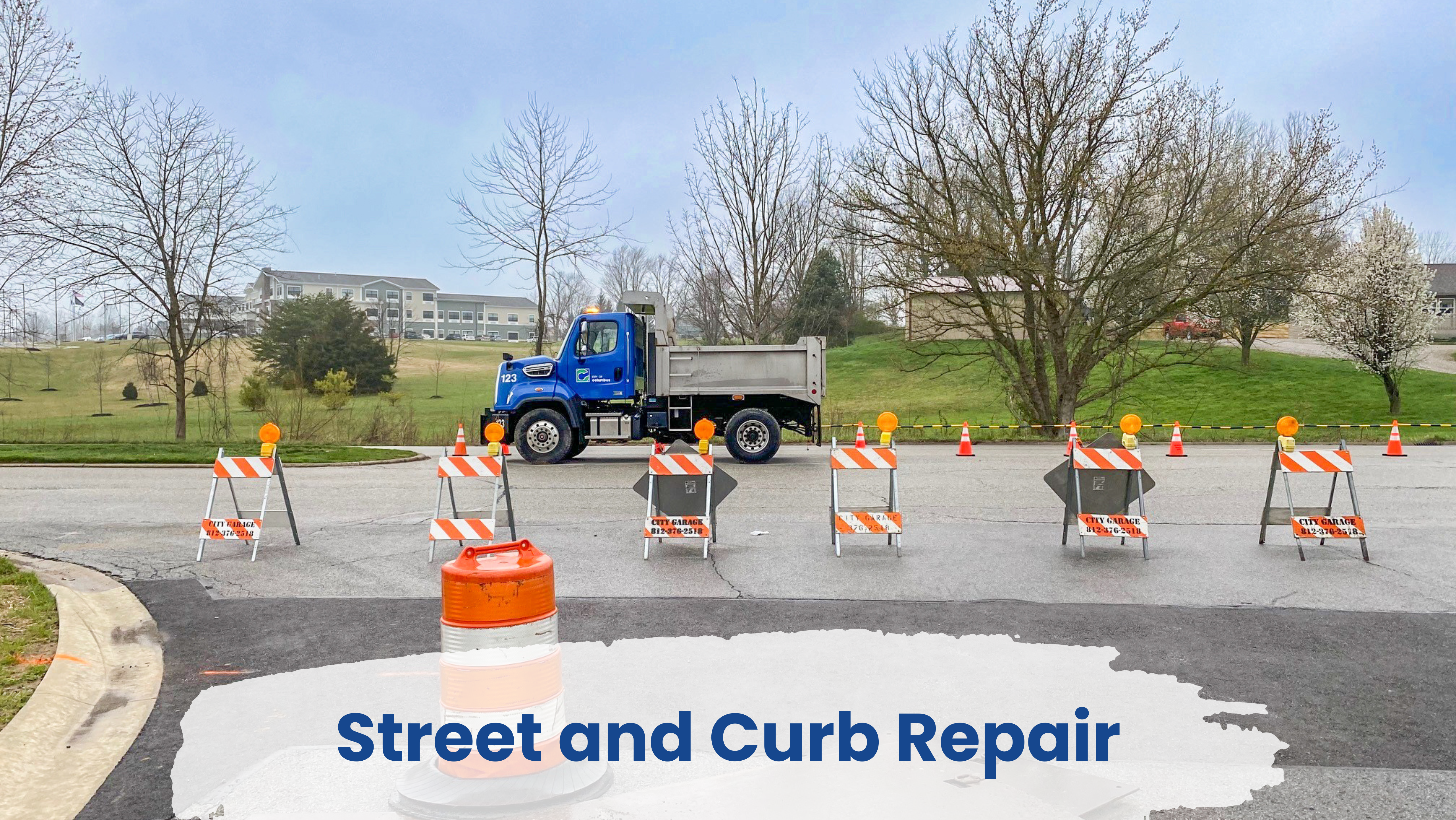 Repaired street and curb with DPW truck in background