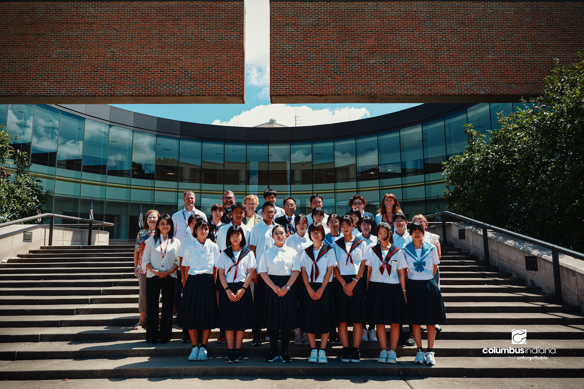 A delegation of students and school officials from Miyoshi-Minami Junior High School, the City of Columbus and Bartholomew Consolidated School Corp., pose for a photo on the steps of Columbus City Hall in Columbus, Ind., Thursday, Aug. 20, 2026. The