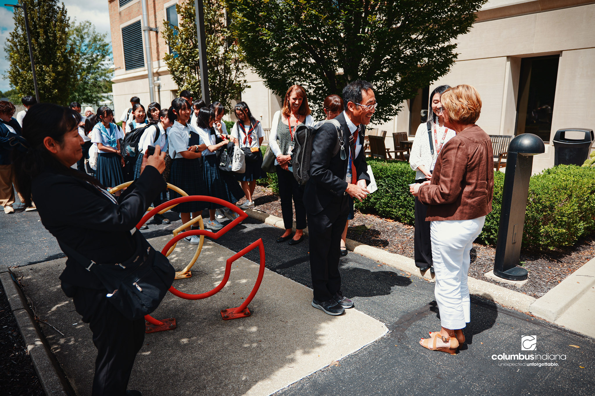 Miyoshi-Minami Junior High School Principal Hioki Mutsuchika, left, greets Executive Assistant to the Mayor Nancy Wagner outside Columbus City Hall in Columbus, Ind., Thursday, Aug. 20, 2026. A delegation of students and school officials from Miyoshi