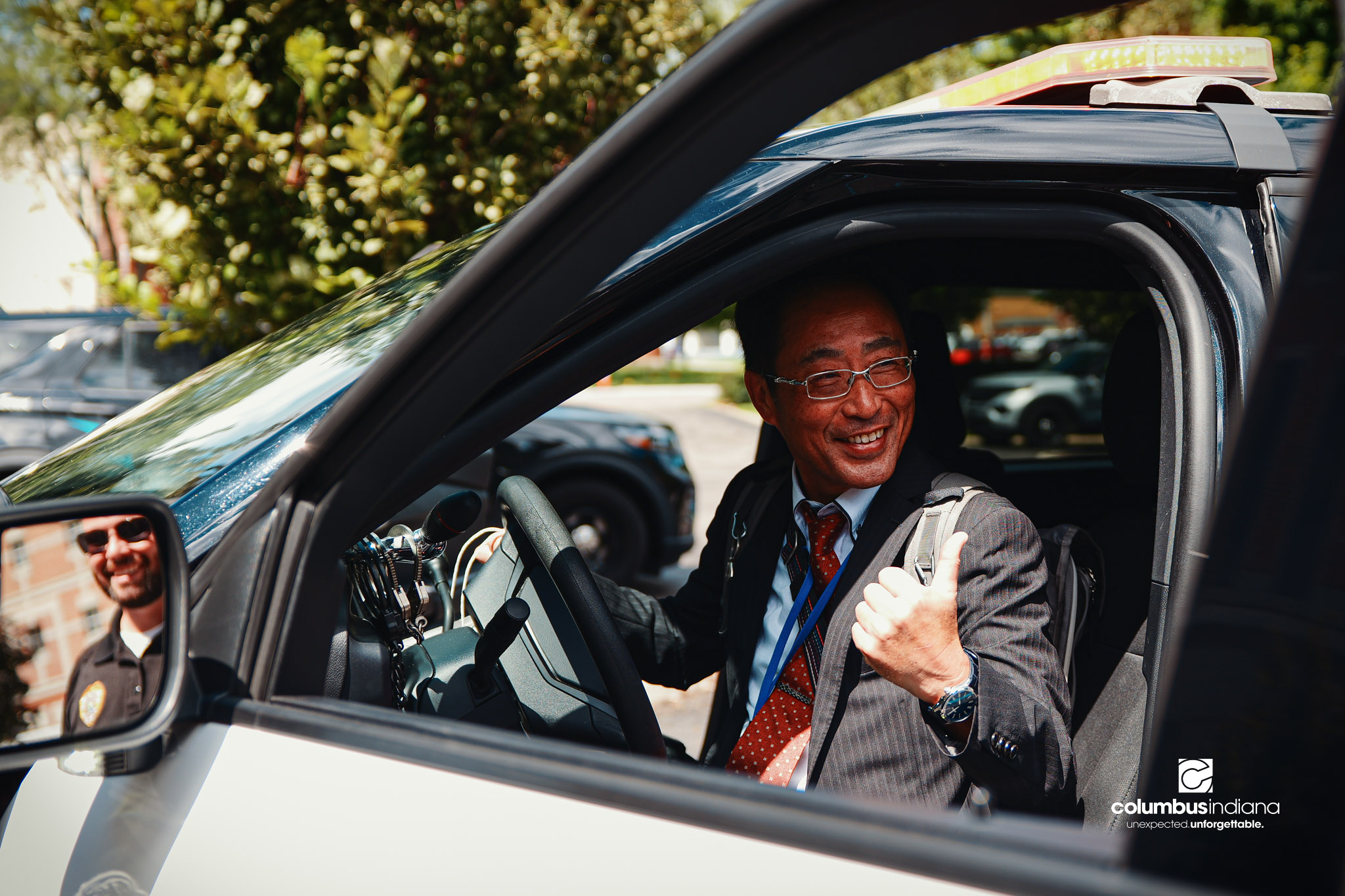Miyoshi-Minami Junior High School Principal Hioki Mutsuchika poses for a photo in Columbus Police Lt. Skylar Berry’s police cruiser during a tour of the Columbus Police Department in Columbus, Ind., Thursday, Aug. 20, 2026. Miyoshi is Columbus’ s