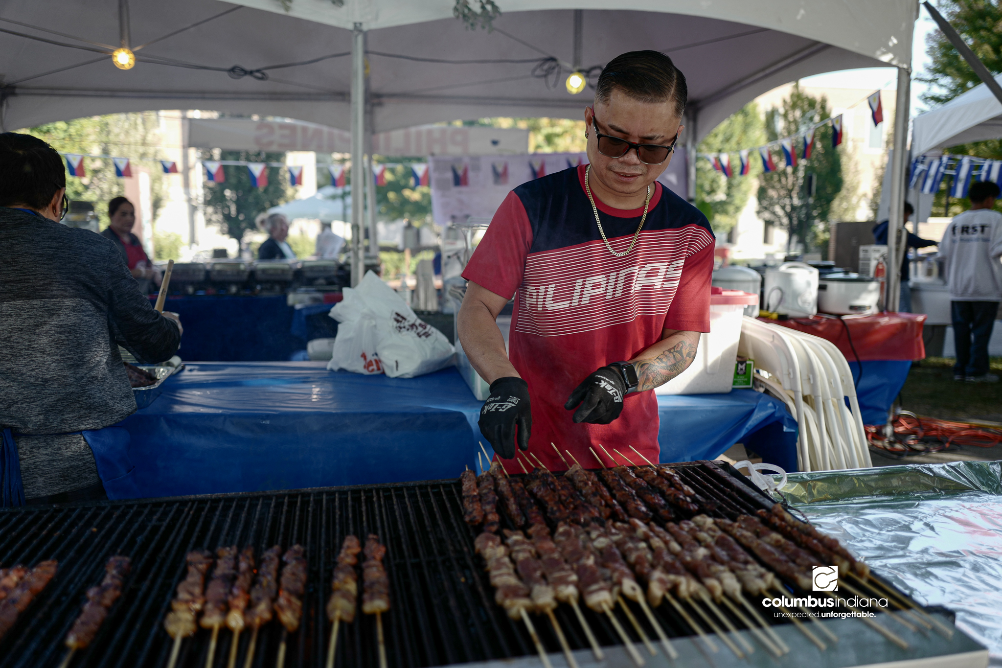 Various images of the sights of Ethnic Expo in Columbus, Indiana. The photos show food, people of different ethnicities and performances as well tents and other spaces vendors are using.