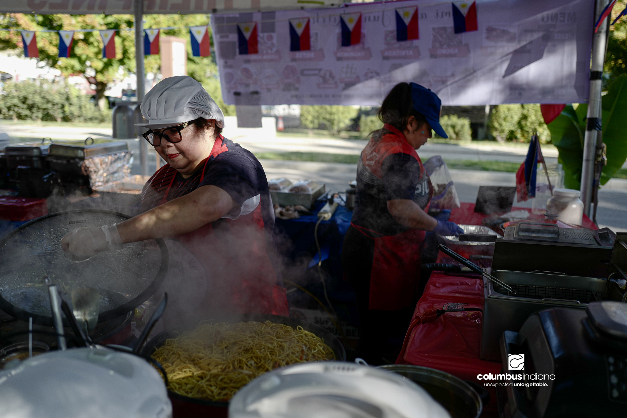 Various images of the sights of Ethnic Expo in Columbus, Indiana. The photos show food, people of different ethnicities and performances as well tents and other spaces vendors are using.