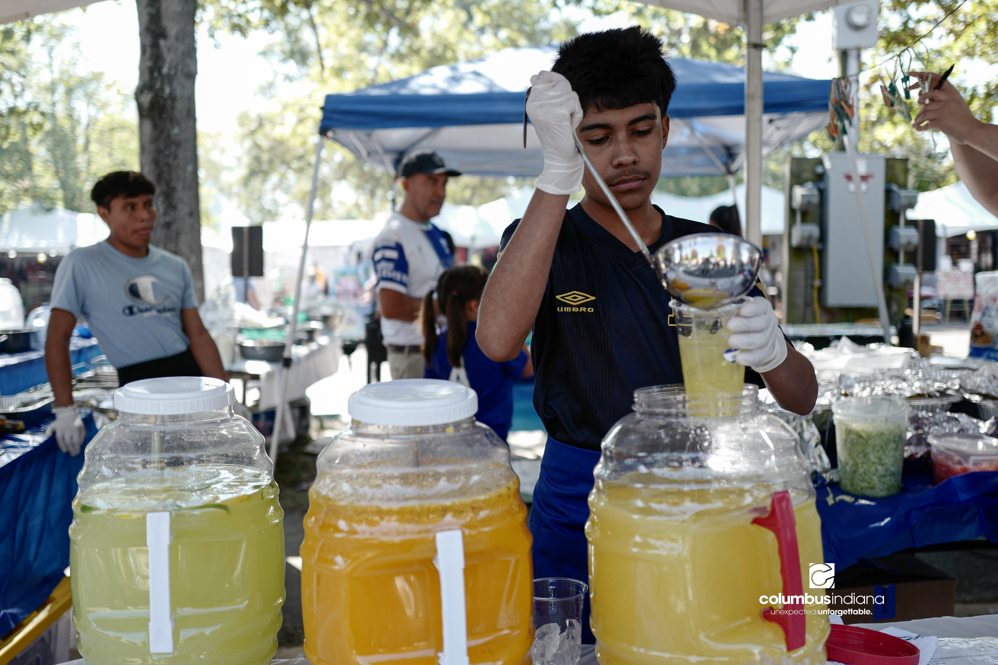 Various images of the sights of Ethnic Expo in Columbus, Indiana. The photos show food, people of different ethnicities and performances as well tents and other spaces vendors are using.